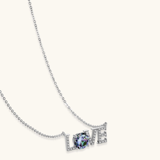 Sterling silver LOVE necklace with brilliant moissanite center stone and pavé details on neutral background.