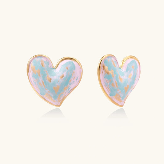 Heart-shaped stud earrings with swirled turquoise and pink enamel in gold-plated frames on cream background