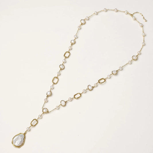 Long gold-plated necklace with alternating freshwater pearls and crystal bezels, featuring a large baroque pearl pendant