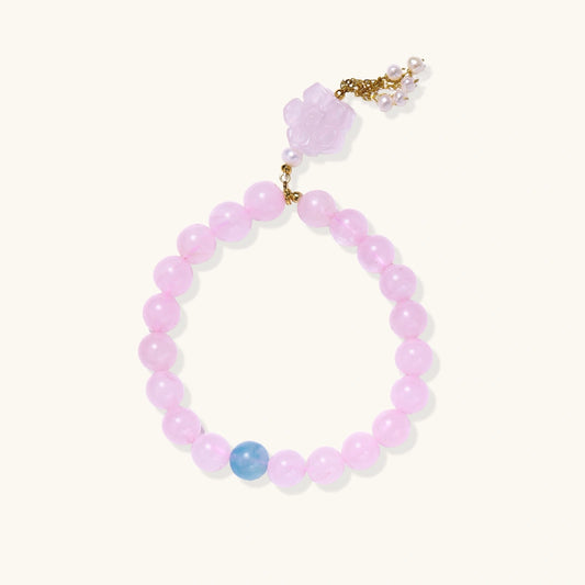 Stretchy beaded bracelet with pink rose quartz, blue aquamarine, carved floral pendant, and pearl tassel clasp.