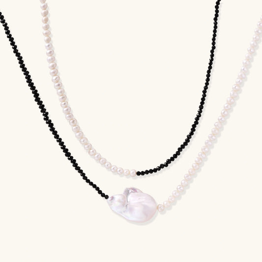 Double-strand necklace with black faceted quartz and white pearls featuring an oversized baroque pearl centerpiece