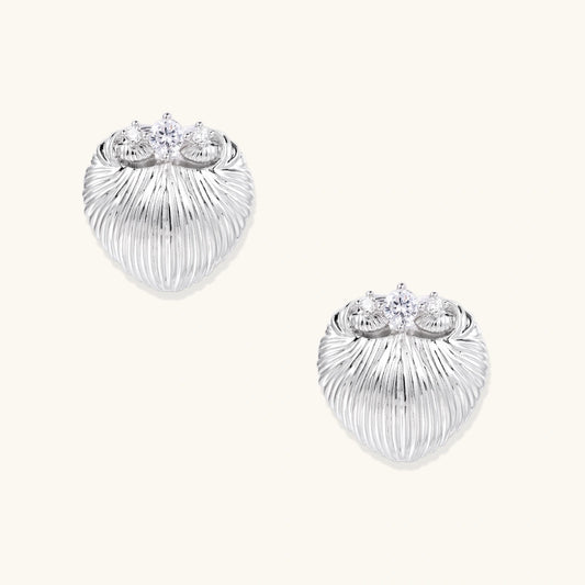 White gold-plated shell-textured stud earrings with three zirconia crystals on ridged surface against cream background.