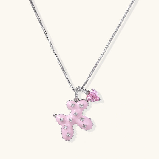 Pink enamel teddy bear pendant with crystal accents and heart charm on white gold chain