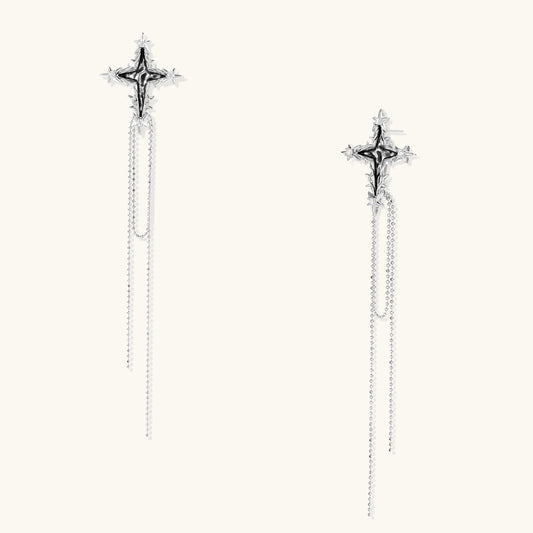 Long silver threader earrings with ornate cross-star design and delicate dual chain tassels on white background