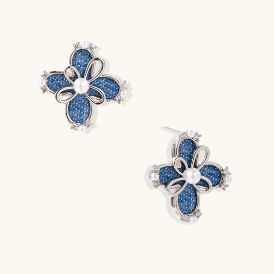 Blue denim fabric flower studs with white gold plated petals, pearl center, and zirconia accents on white background