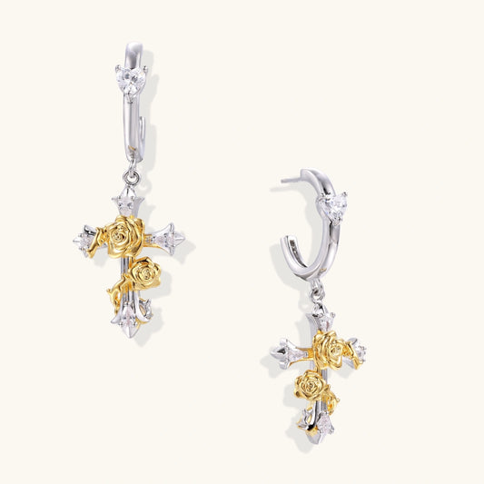 Ornate gold plated cross drop earrings with rose details and sparkling zirconia stones on white background.