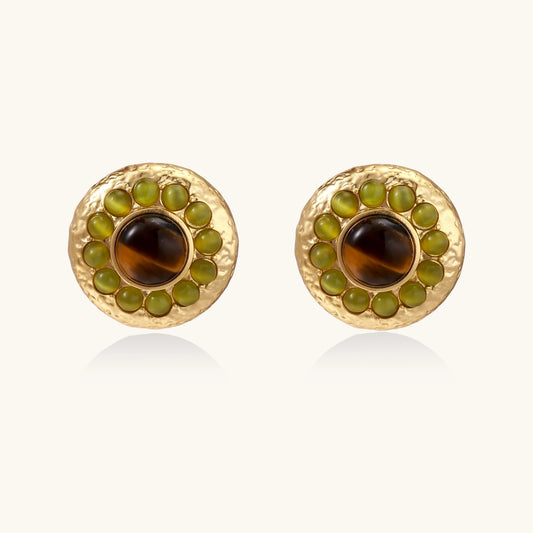 Round hammered gold studs with brown tiger's eye center surrounded by olive green liuli stones on white background.