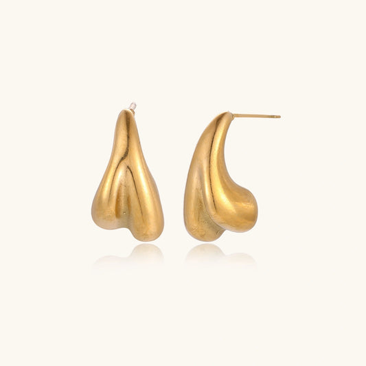 Organic sculptural gold stud earrings with fluid matte finish on cream background
