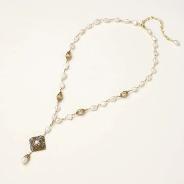 Y-shaped necklace with freshwater pearls, gold filigree stations, and ornate diamond-shaped centerpiece with pearl drop