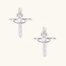 White gold plated cross earrings with orbital ring & zirconia stones on cream background
